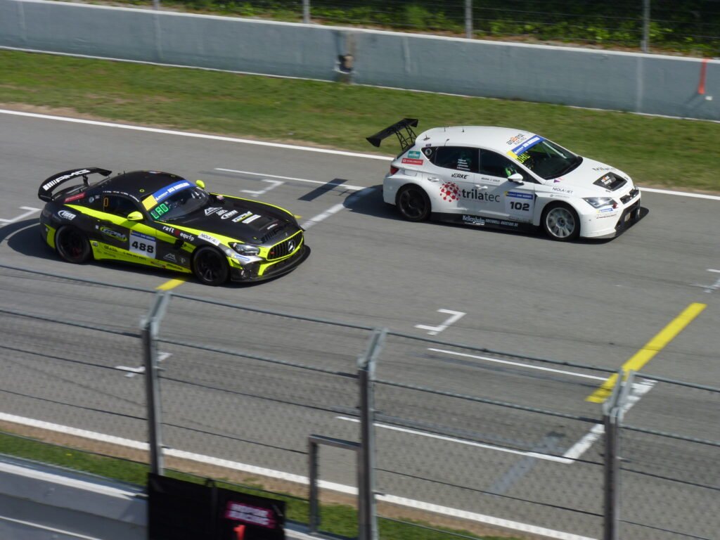 Mercedes AMG GT4 with an SEAT Cupra in the straight of Barcelona track